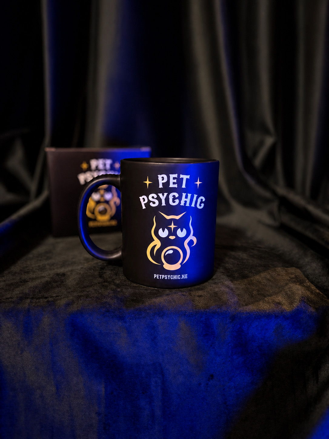 Pet Psychic Coffee Mug — black ceramic mug with cat-and-crystal-ball design